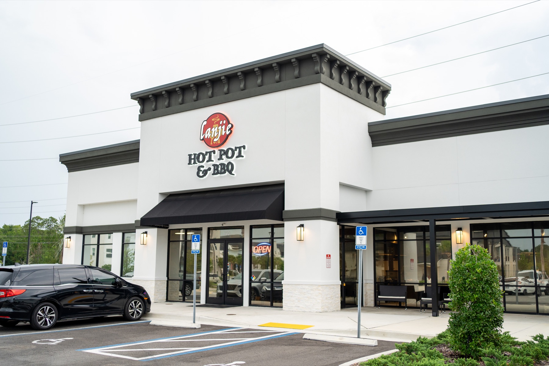 The Lanjie Hot Pot & BBQ storefront in Saint Johns, Florida, with its lit sign and black awning